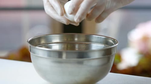 Cracking Egg into Stainless Steel Bowl