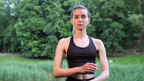 Woman in Active Wear Stands in Park
