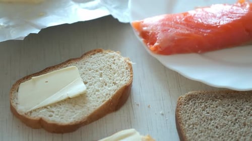 Spreading Butter on Bread with Salmon Nearby