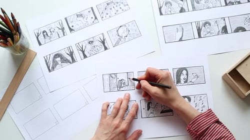 Storyboard Artist Drawing Cartoon Panels on Table