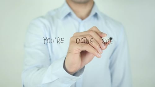 Man Writing 'You're Doing Great' on Glass