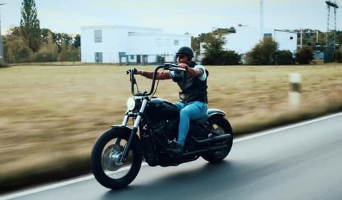 Man Riding Motorcycle on Paved Road
