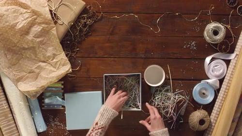 Hands Wrapping Christmas Present Overhead View