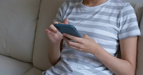 Frau benutzt Handy zu Hause