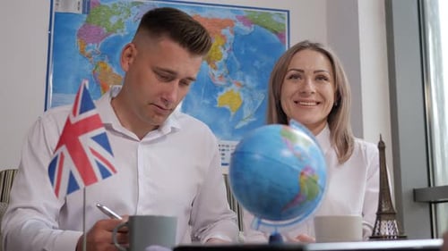 Couple Planning Travel Receiving Passports in Bright Office