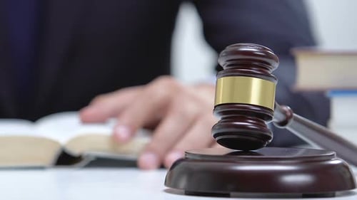 Lawyer Studying Law Book with Gavel on Desk