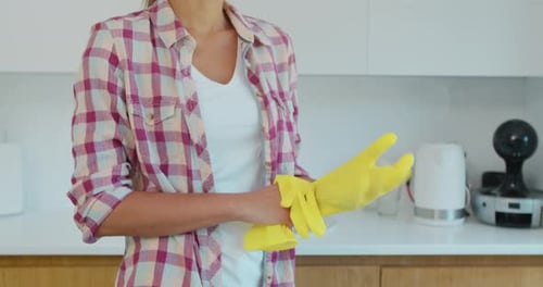 Determined Wife Ready To Start Cleaning the Household, Puts on Yellow Gloves.