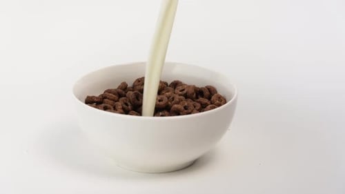 Milk Being Poured into Chocolate Cereal Bowl