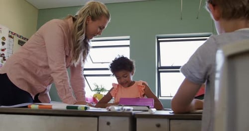 Teacher Helping Student in Classroom