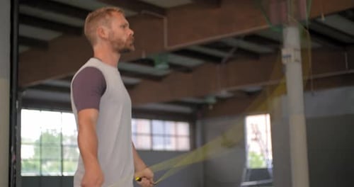 Junger erwachsener Mann macht Springübungen mit Springseil während des Fitness-Sporttrainings