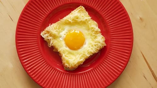 Top View of Toast with Fried Egg and Cheese on Wooden Kitchen Table