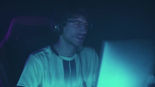 Man with Headset Plays Video Game in Dark Room