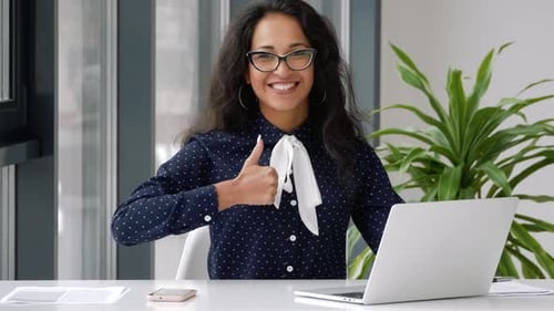 Smiling Woman Working at Laptop Gives Thumbs Up