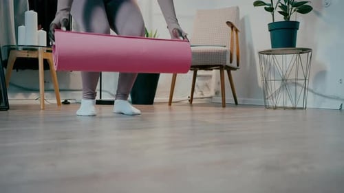 Woman Unrolls Yoga Mat for Home Workout