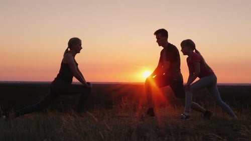 Familie mit Kind macht gemeinsam Übungen an einem malerischen Ort bei Sonnenuntergang