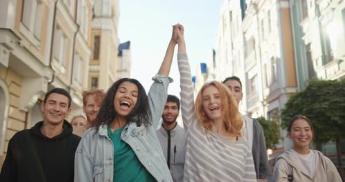 Two Happy Mixed Races Women Lift Hands Up Together in a Mass Protest Against Racism