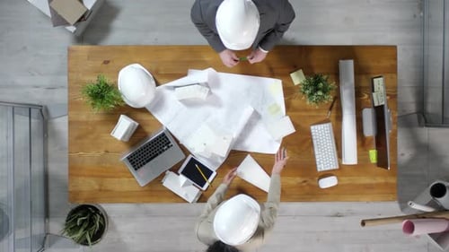 Architects Discussing Construction Project at Table Overhead