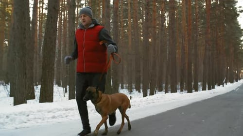 Hombre activo de mediana edad corriendo con perro