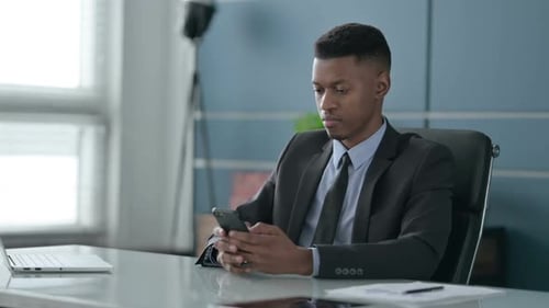 Successful African Businessman Celebrating on Smartphone