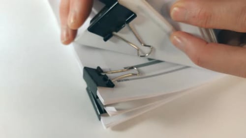 Hands Flipping Through Stack of Documents