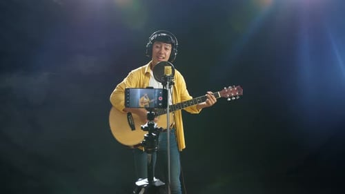 Young Musician Performing with Acoustic Guitar in Studio