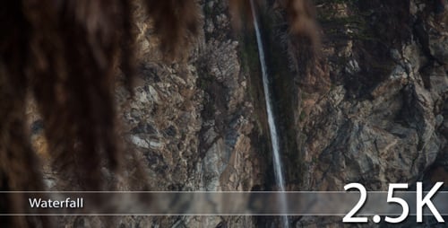 Waterfall Cascading Down Rocky Cliffside with Palm Fronds