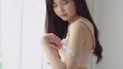 Young Woman Measuring Her Arm With Tape Measure