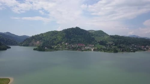 Aerial Downwards pan of Lanscape shot of valley with lake and woodland and houses