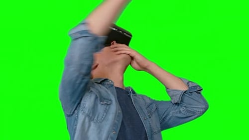 Young Man Using VR Headset on Green Screen