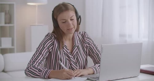 Woman Working From Home, Taking Notes During Video Call