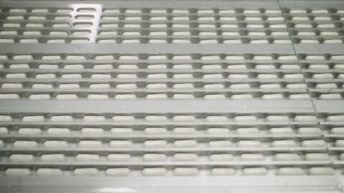Production of Pharmaceuticals and Drugs Large Number of Capsules in Motion White Tablets on the