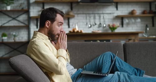 Man Working On Laptop On Sofa
