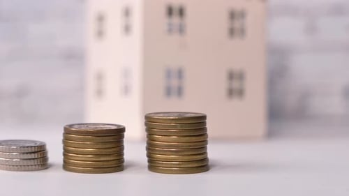 the Concept of Finance Concept with Stack of Coins and House on Table