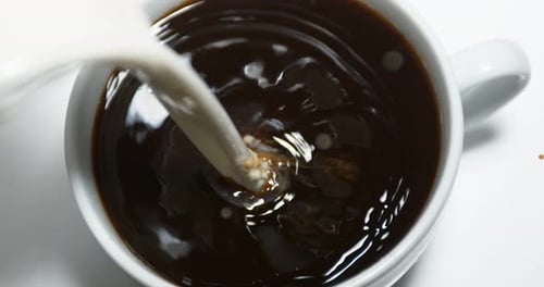 Milk Being Poured into a Mug of Coffee