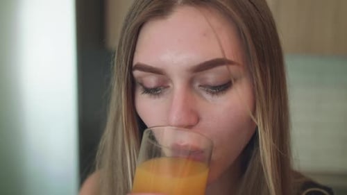 Woman Drinking Orange Juice Close Up at Home