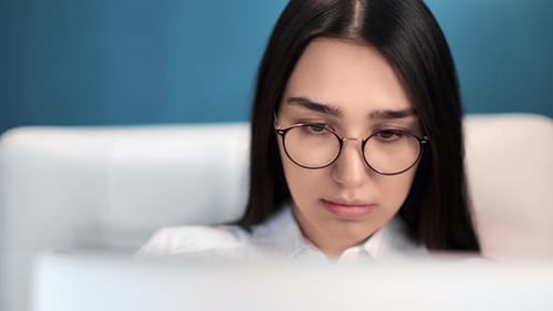 Young Woman With Glasses Using Computer at Home