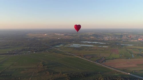 Heart Shaped Balloon Over Rural Landscape at Sunset