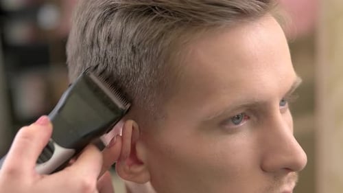 Man Receives a Haircut at the Barber Shop