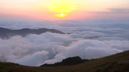 Morgen in den Bergwiesen und Sonnenaufgang über den Wolken