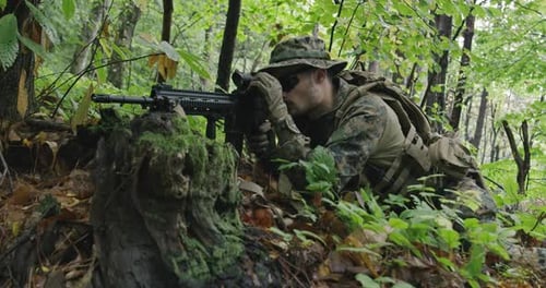Adult with Rifle Lying in Forest Camouflage