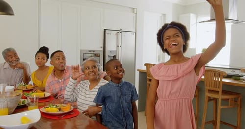 Family Celebrates Together Around Kitchen Table