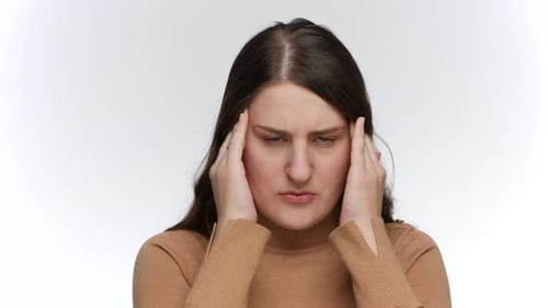 Woman Rubbing Temples Experiencing a Headache