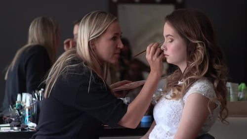 Makeup Artist Applying Makeup to Young Woman