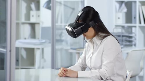 Asian Woman Using Interactive Touchscreen and VR Headset in Office