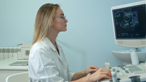 Jeune femme médecin blonde regardant un résultat d'échographie
