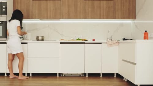 Woman Prepares Food in Modern Home Kitchen