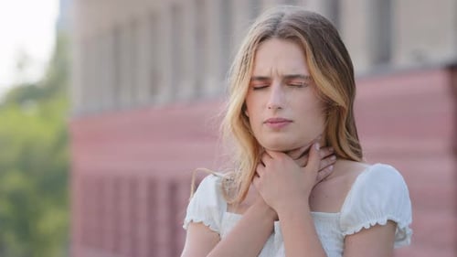 Woman Clutching Throat Due to Illness