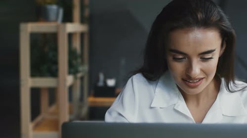 Woman Smiles While Looking at Computer Screen