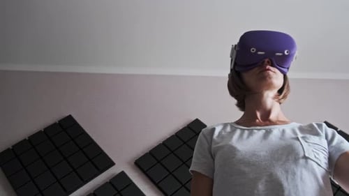 Woman Using VR Headset and Controllers in Room