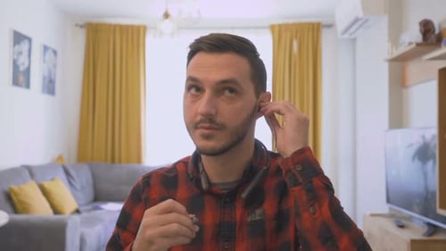 Man Putting in Headphones Speaking